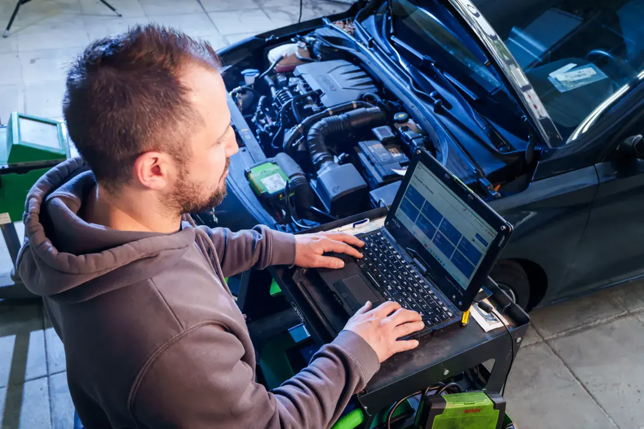 Fahrzeugdiagnose per Laptop am Motorraum